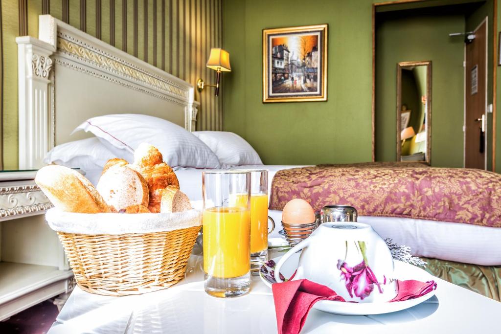 a hotel room with a table with a basket of bread and orange juice at Hotel Regence Paris in Paris