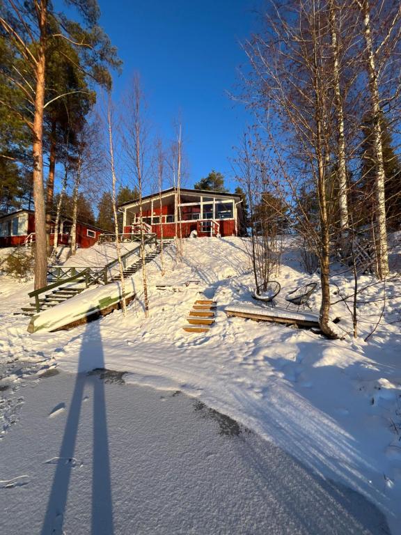 a snow covered yard with a house in the background at Two bedroom duplex with peaceful views in Jyväskylä