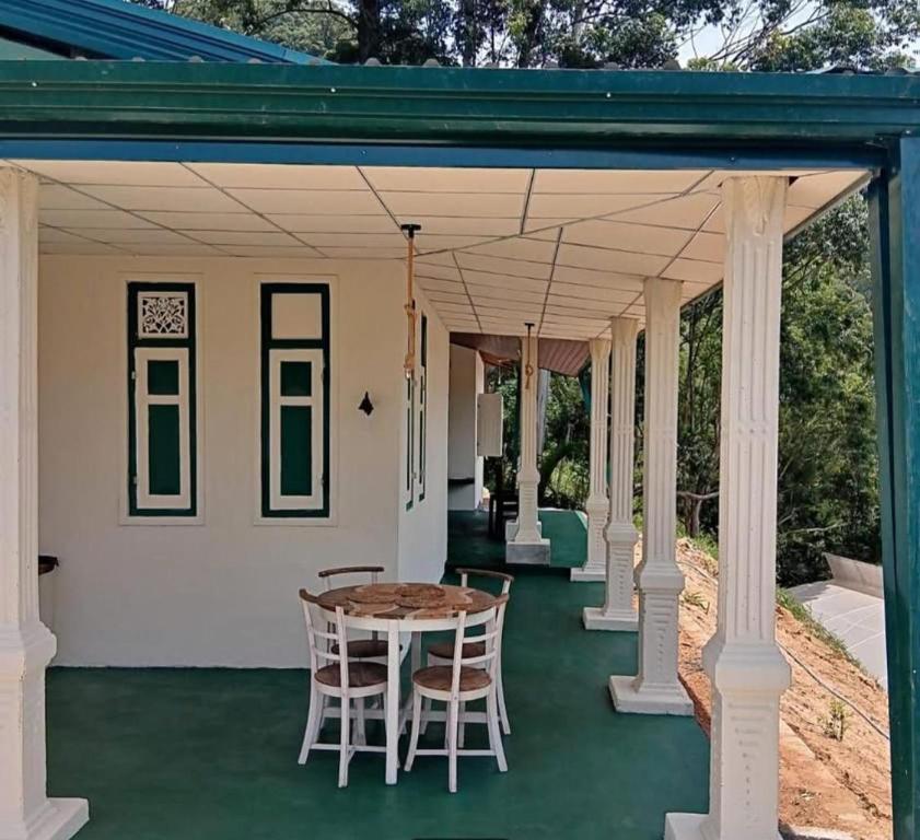 - une terrasse couverte avec une table et des chaises dans l'établissement Rathkarawwa Heights, à Haputale
