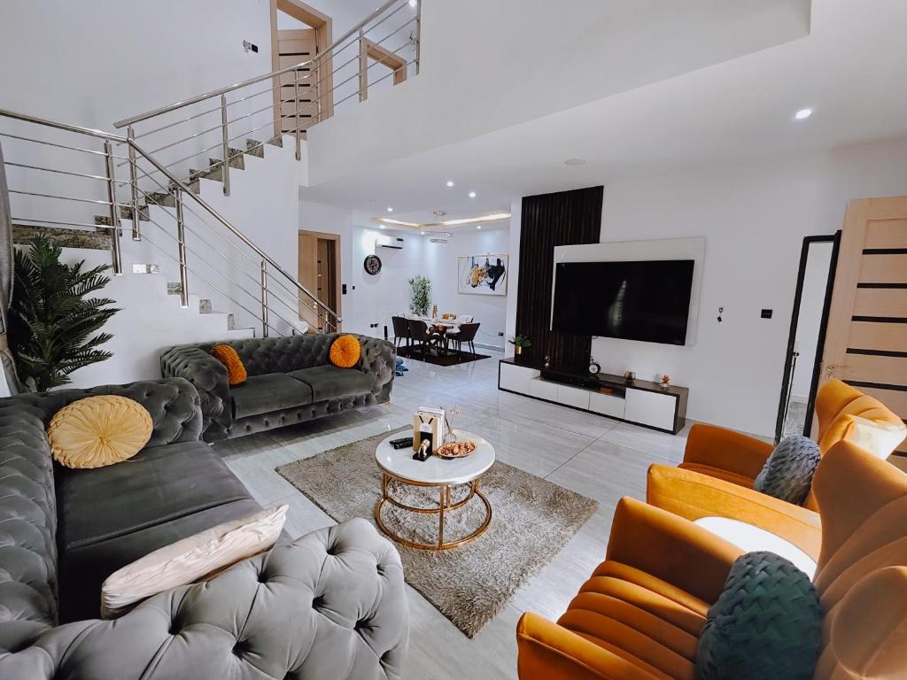 un grand salon avec des canapés et une télévision dans l'établissement Bourdillon 3 Bedroom Luxury Apartment Ikoyi - 24hr Power, Wifi, Highly Secured, à Lagos