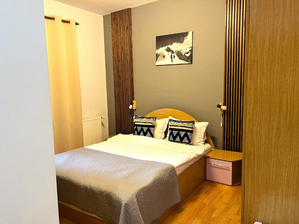 a small bedroom with a bed in a room at 5th Forest Villa – Family Retreat, Garden & BBQ in Predeal