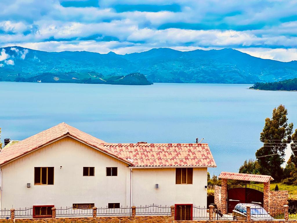 uma casa com vista para um lago e montanhas em Cabaña Valle De La Laguna, jacuzzi y vista al Lago em Aquitania