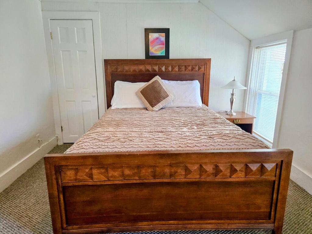 a large wooden bed in a bedroom with a window at Gulf Stream House - Hammondsport Getaway Apartment Unit 11 in Hammondsport