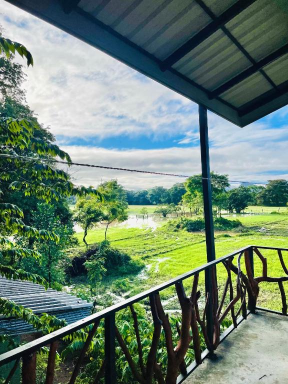 a balcony with a view of a field at Dimuthu Green Villa in Sigiriya