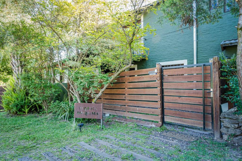 Y qué sea lo que sea في Balneario Ipora: حاجز خشبي مع وجود لافتة أمام المنزل