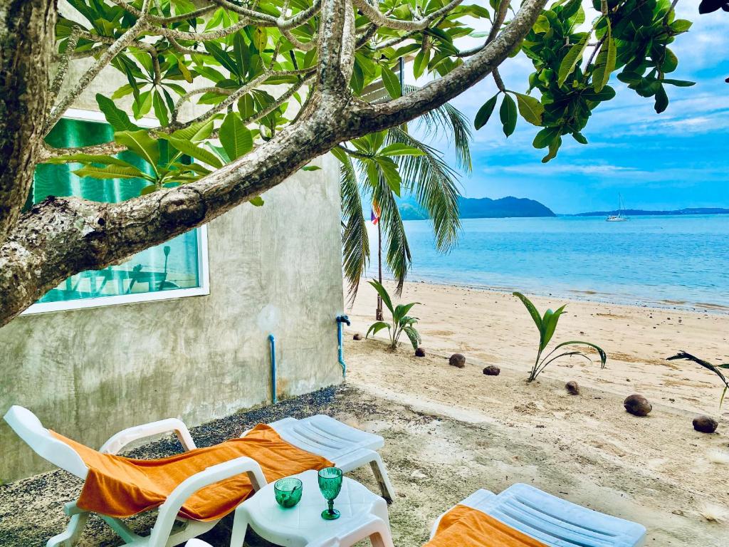 einen Tisch und Stühle am Strand mit Meerblick in der Unterkunft Khao Khad Beach Bungalow in Ko Thanan