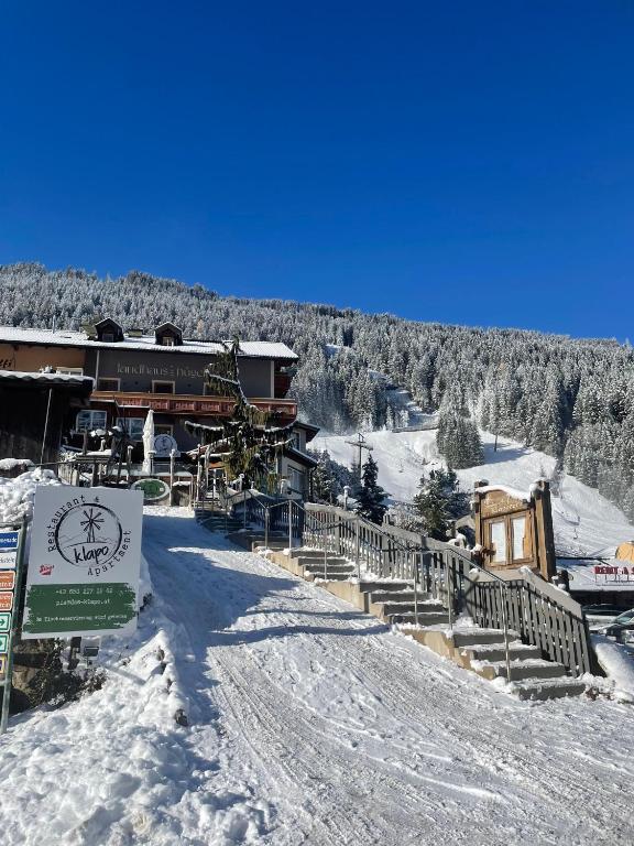 a ski lodge in the snow with a sign in front at Apartment Klapo in Bad Gastein