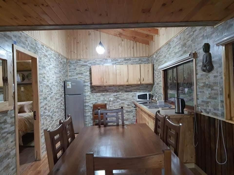una cucina con un tavolo di legno e una sala da pranzo di Centro Turístico Mayu Wasi a Los Angeles