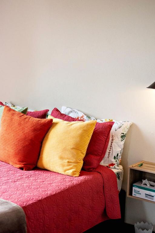 a bed with colorful pillows on top of it at Pecan and Lime Inn The Third Den in Pretoria