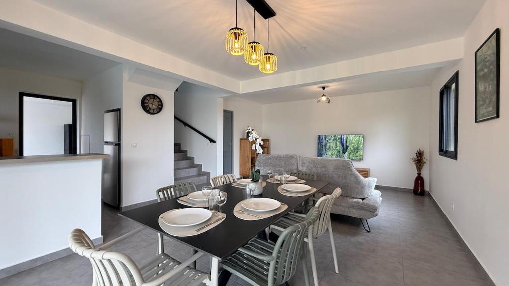 une salle à manger et un salon avec une table et des chaises dans l'établissement Maison Amalia, à Sainte-Suzanne
