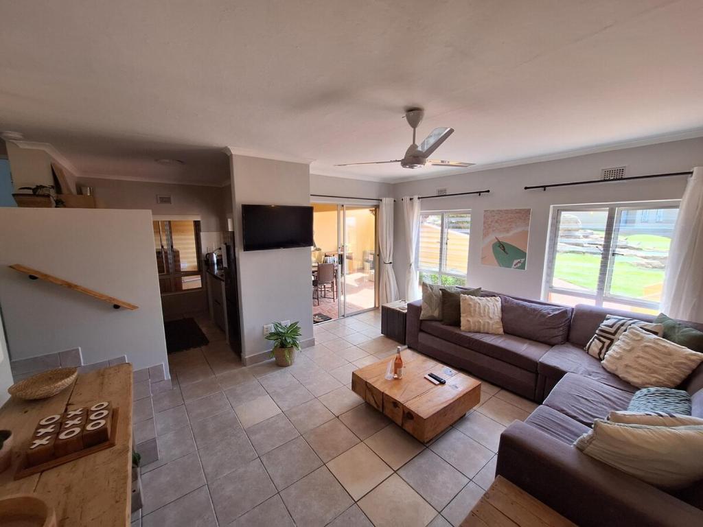 a living room with a couch and a table at Unit 40 Chakas Rock Chalets in Ballito