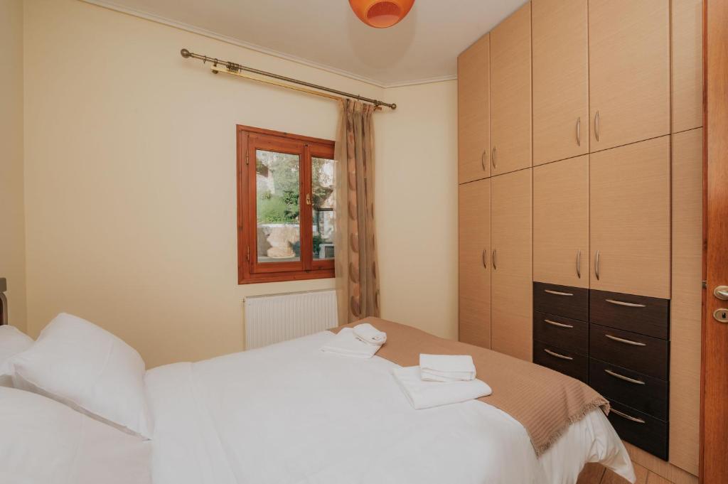 ein Schlafzimmer mit einem weißen Bett und einem Fenster in der Unterkunft Arachova Comfort in Arachova