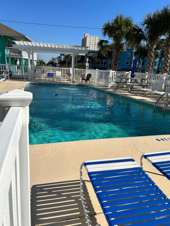 a large swimming pool with blue water and chairs at Relax at the Beach in Myrtle Beach