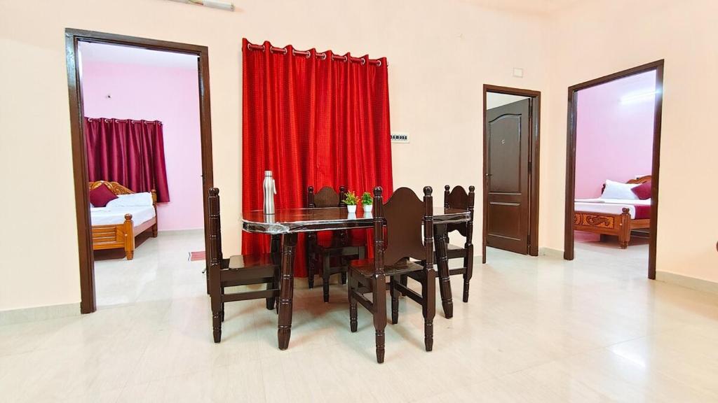 a dining room with a table and a red curtain at 10 mins to Rock Beach-Sérénade Homestay in Puducherry