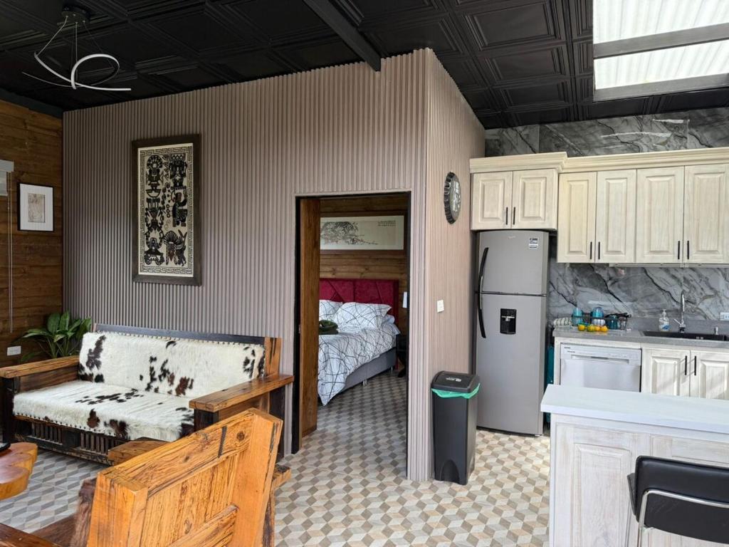 cocina con sofá y cama en una habitación en Mini House Reserva Natural, en Guarne