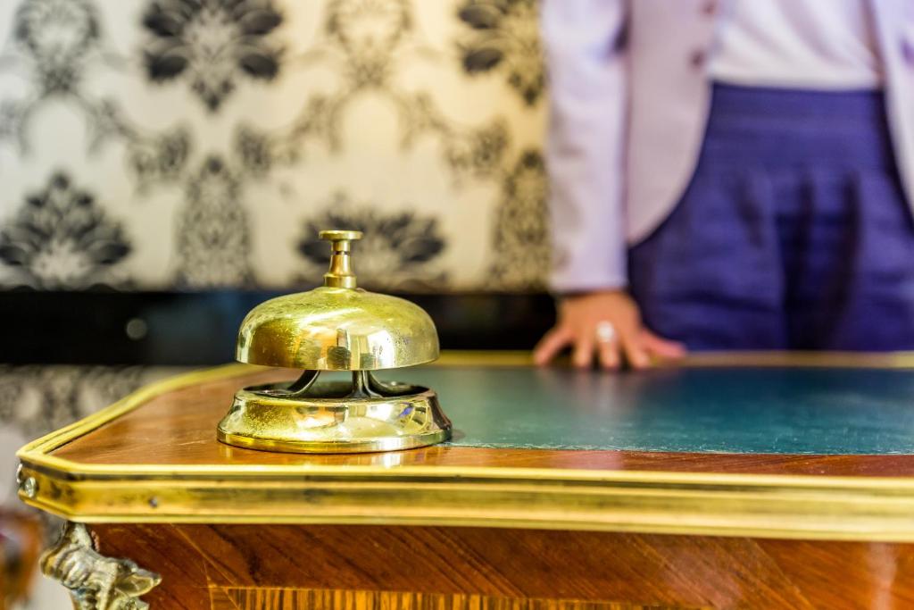 a table with a gold phone on top of it at Hotel Regence Paris in Paris