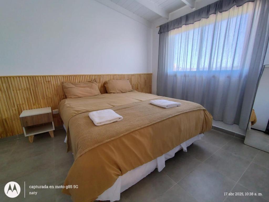 a bedroom with a large bed with two towels on it at Duplex Frente mar in Playa Dorada