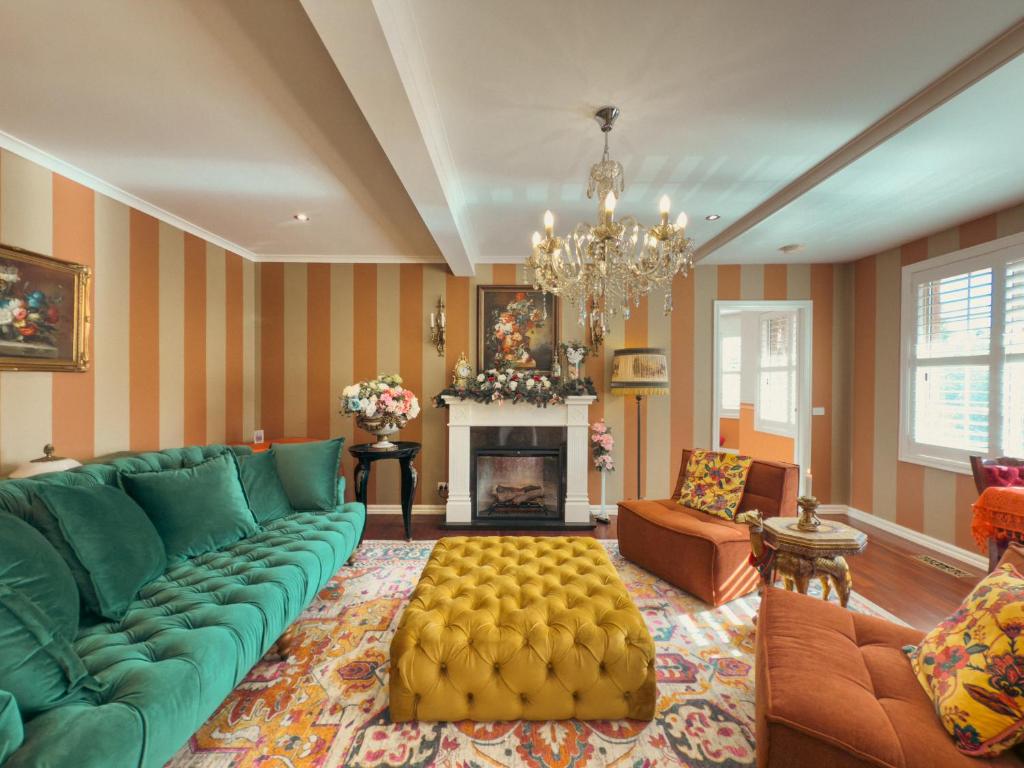 un soggiorno con divano verde e camino di Pudding's Home Puffing Billy Dandenong Mountain View Retreat a Upwey