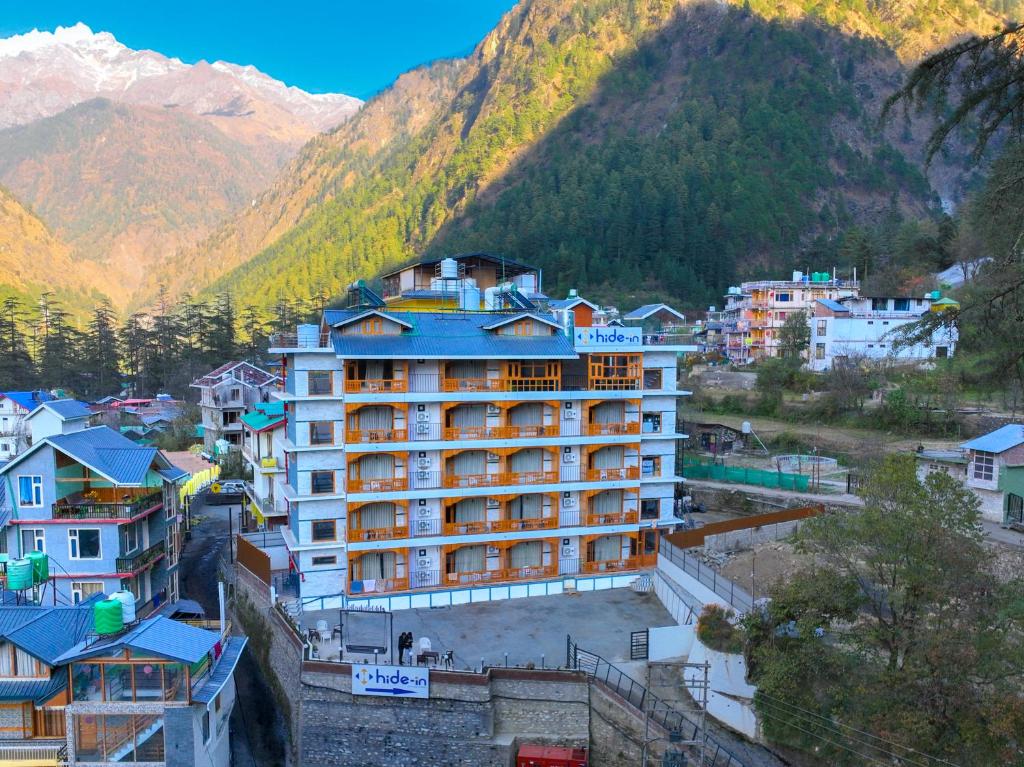 un hotel en una ciudad con montañas al fondo en Hide-In Kasol, en Kasol