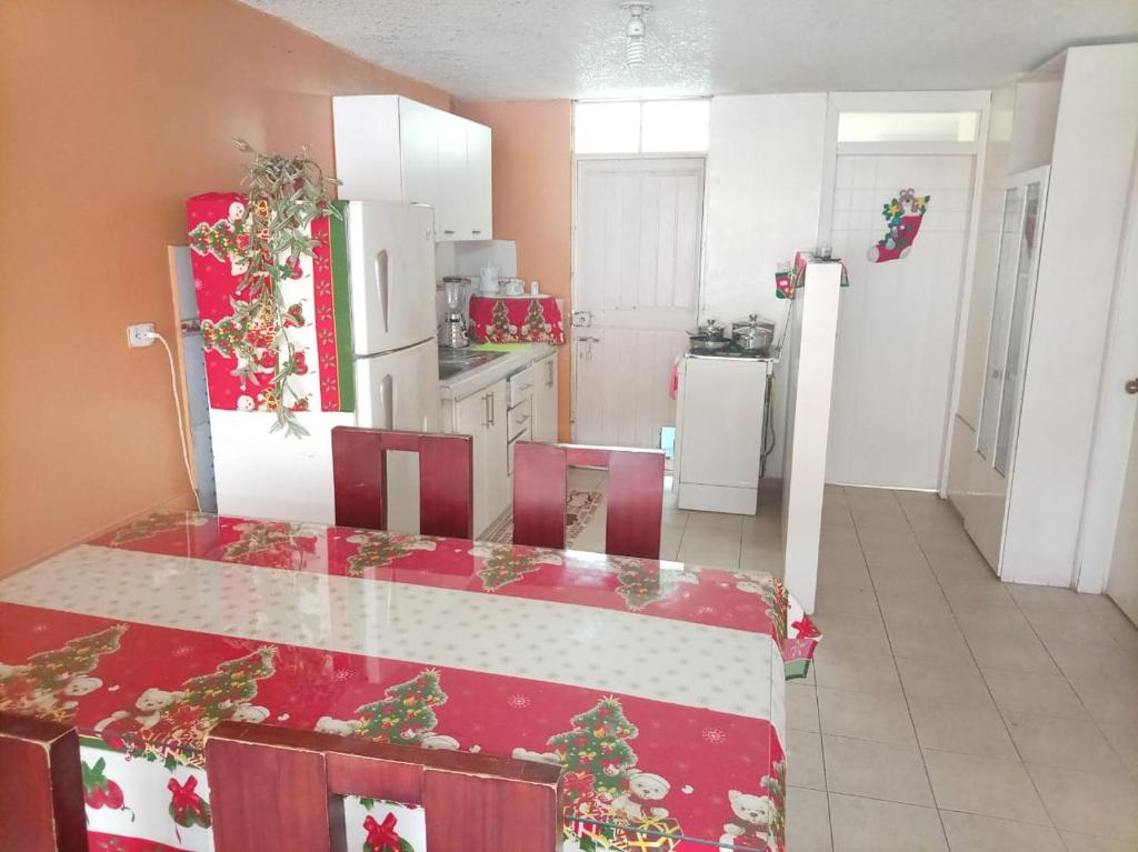 une cuisine avec une table et des chaises avec des cadeaux de Noël dans l'établissement Sultana de los Andes Apartment, à Riobamba