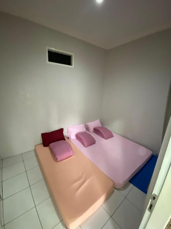 a room with a bed with pink pillows on it at Villa Pangalengan in Palayangan