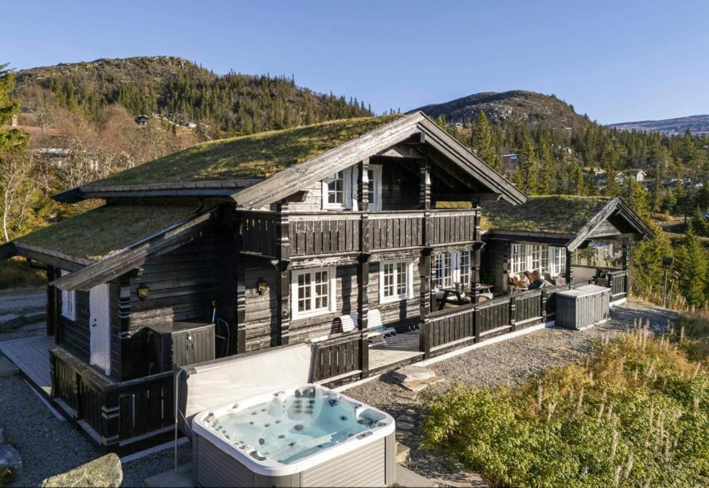 an old house with a grass roof with a hot tub at Family Cabin With Jacuzzi At Tempelseter in Eggedal