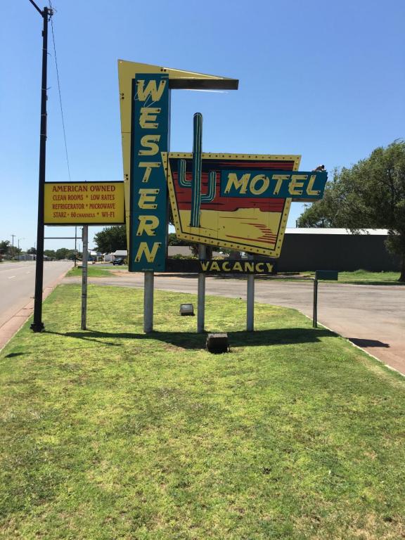 una señal para un motel al lado de una carretera en Western Motel en Sayre