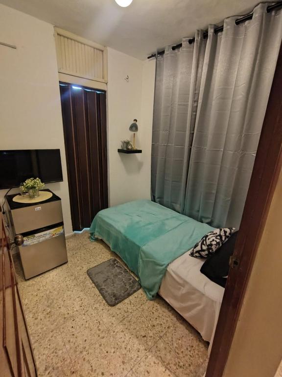 a small bedroom with a bed and a window at La Guarida de Mela in Santo Domingo