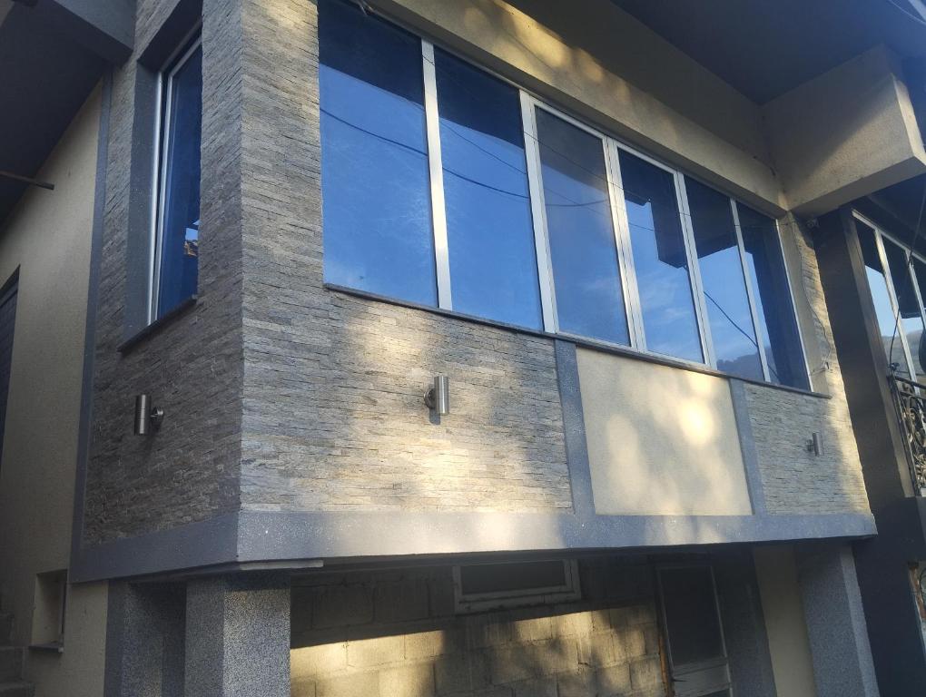 ein Gebäude mit Glasfenstern an der Seite in der Unterkunft Lela lux in Jošanička Banja