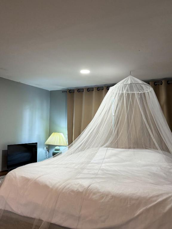 a white bed with a mosquito net in a bedroom at Pridi cozy home with good location Type A in Bangkok