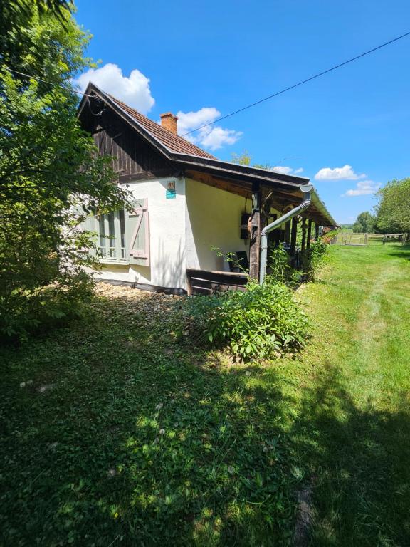 a small house in a field next to a yard at Birsalmafa Vendégház in Bajánsenye