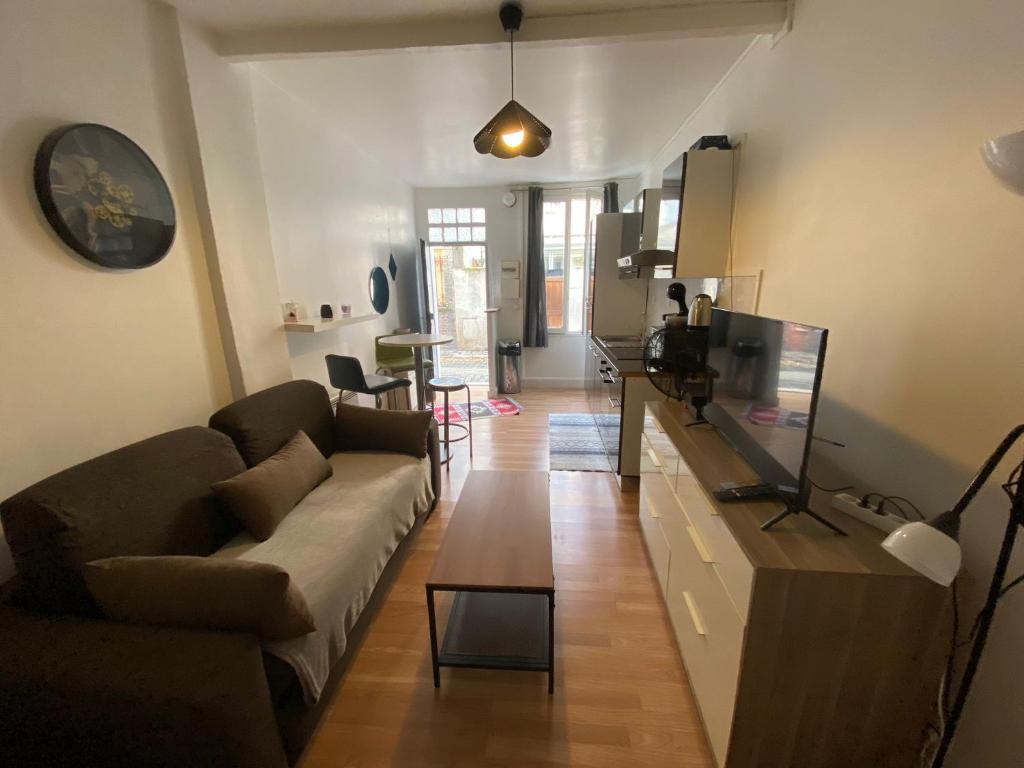 ein Wohnzimmer mit Sofa und Tisch in der Unterkunft Le charles in Paris