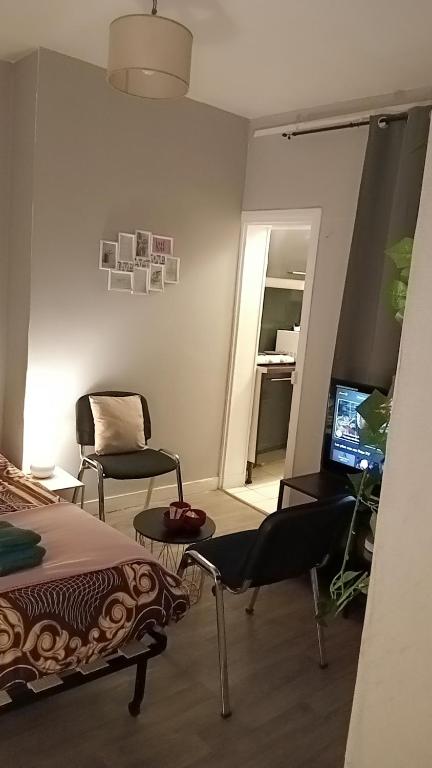 a bedroom with a bed and a chair and a television at Po1-TPSA17-3D- ROOM Paris 17ème in Paris