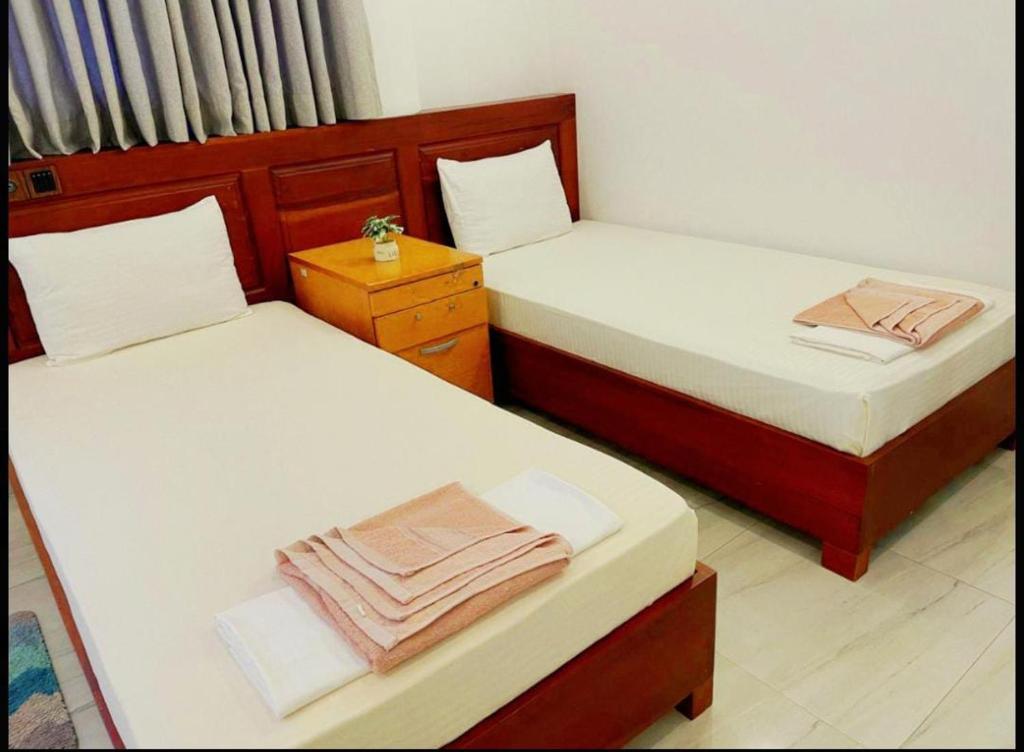 zwei Einzelbetten in einem Zimmer mit Röcken in der Unterkunft Marian Villa in Katunayaka