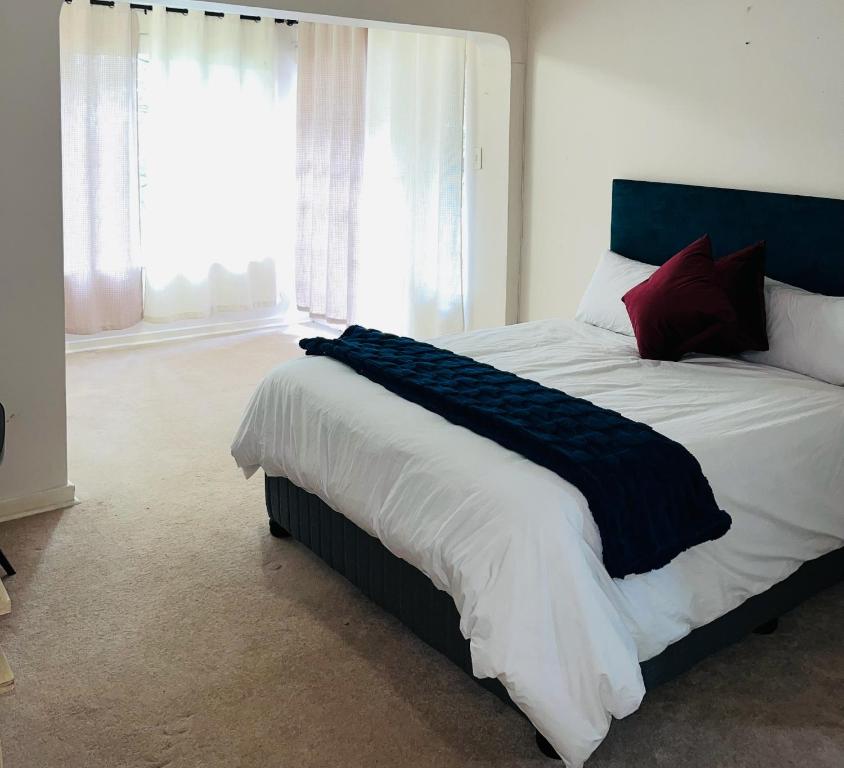 a bedroom with a large bed with a large window at LaPoch Guesthouse in Durban