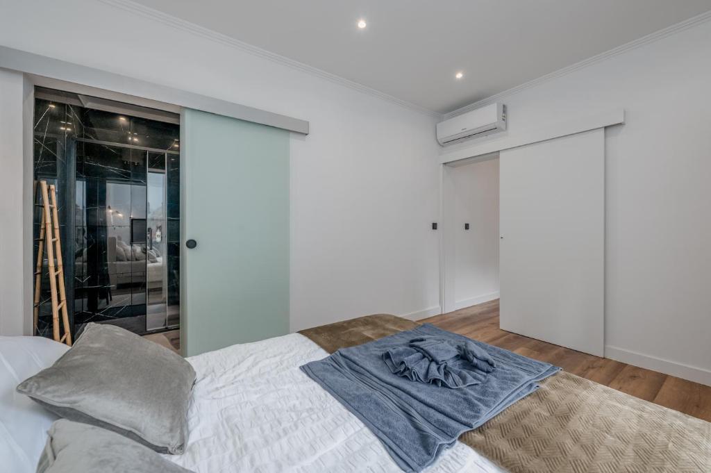 een slaapkamer met een bed met een witte muur bij Stylish 1 Bed Room in Funchal