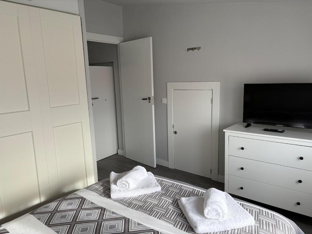 桑坦德Ático recién reformado en Santander的一间卧室配有一张床、一台电视和一个梳妆台