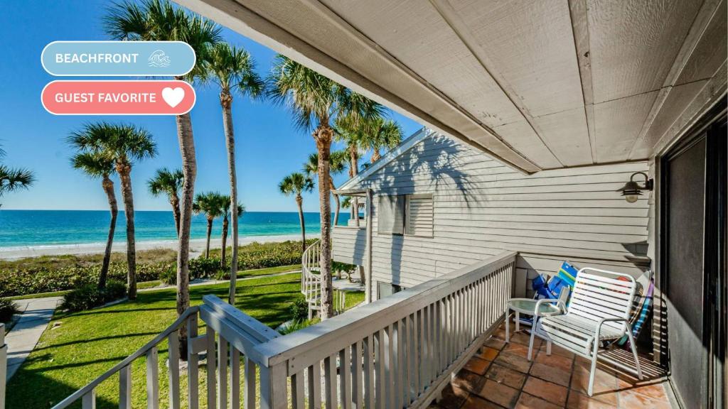 een huis met een balkon met palmbomen en de oceaan bij Beachfront Aldea 6 in Clearwater Beach