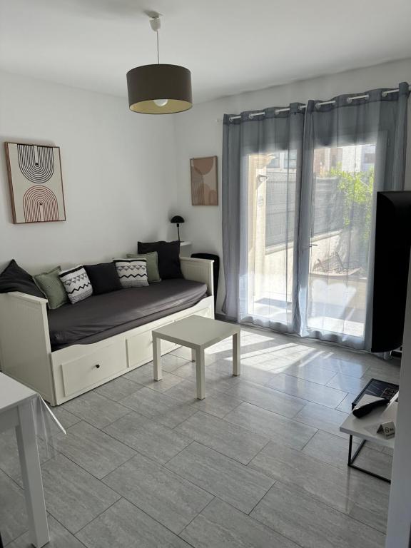 uma sala de estar com um sofá e uma mesa em Chez Allison 3 Étoiles em Cavaillon