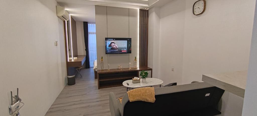 a living room with a couch and a tv on a wall at Formosa Spacious Apartments with Netflix & Pick Up Service by MESA in Nagoya