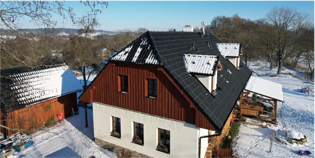 Una vista aérea de una casa con nieve en el techo. en Penzion pod Čeřinkem, en Mirošov
