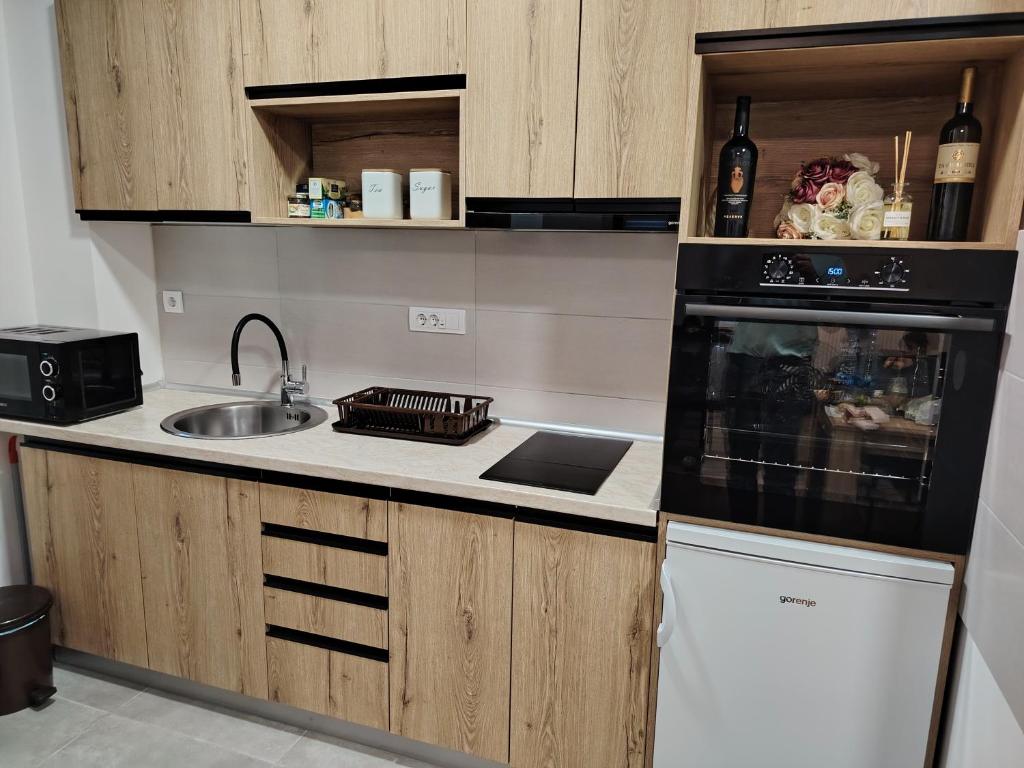 a kitchen with a sink and a stove top oven at Stela Divcinova in Divčibare
