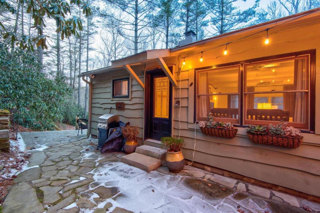 a house with a porch and a dog sitting outside at Orchid Cabin in Banner Elk