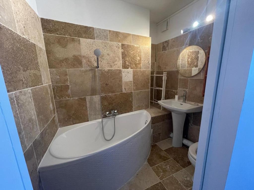 un baño con bañera y lavabo en Comfort with garden, en Fécamp