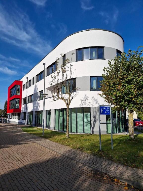 a white building with a tree in front of it at Ferienwohnung Meer-Zeit in Lubmin