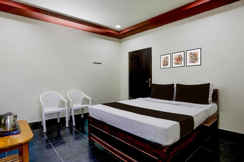 a bedroom with a bed and a table and chairs at Collection O Chirala Beach View Formerly Sea Shell Resort in Vadarevu
