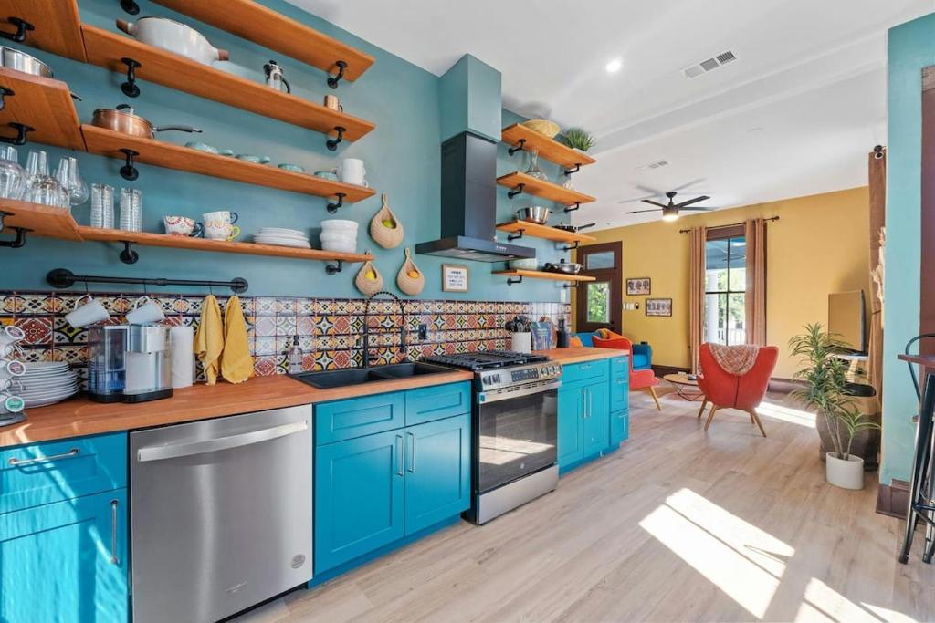 a kitchen with blue cabinets and wooden shelves at Historic French Royal Estate at Capitol, Downtown! in Austin