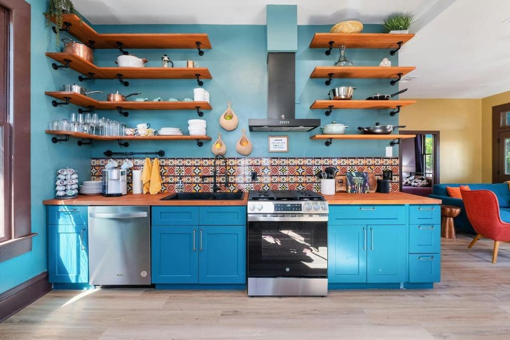 a kitchen with blue cabinets and a blue wall at Historic French Royal Estate at Capitol, UT Downtown in Austin