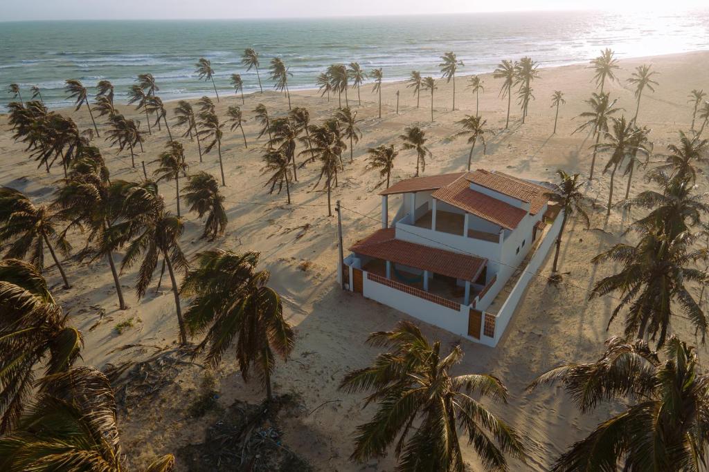 ein Haus am Strand mit Palmen in der Unterkunft Casa Iguana in Trairi