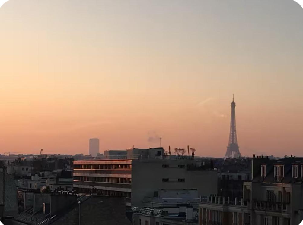 a view of the eiffel tower at sunset at 2 bedrooms in the sky ! in Neuilly-sur-Seine